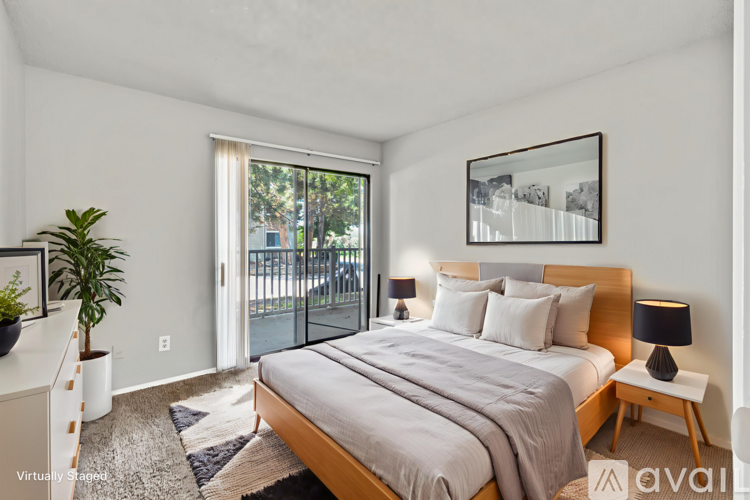 A bedroom with a large bed and a balcony.