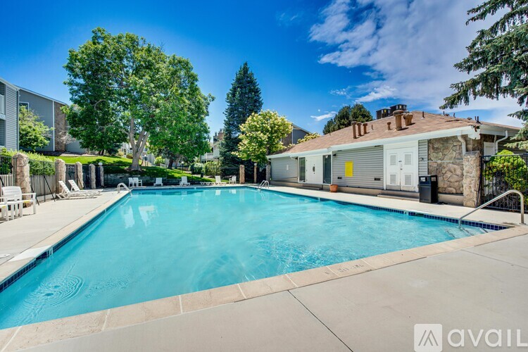 A swimming pool surrounded by a concrete patio and a stone wall.