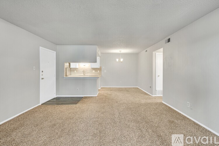 A spacious room with carpeted floor and a window with blinds.