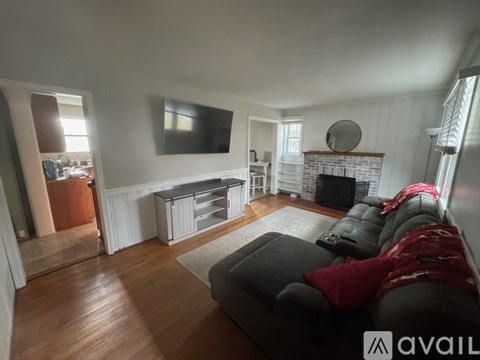 A living room with a grey couch and a fireplace.
