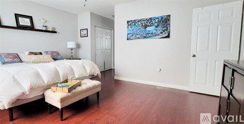 A bedroom with two beds and a painting on the wall.