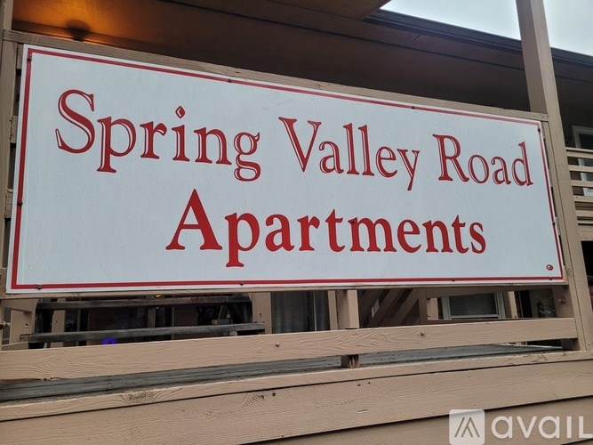 A sign for Spring Valley Road Apartments is displayed on a building.