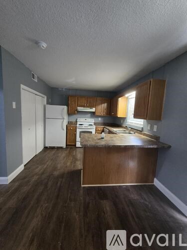 A kitchen with wooden cabinets and a white refrigerator.