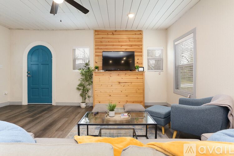 A living room with a blue door and a wooden wall.