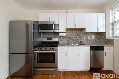 A kitchen with a stainless steel refrigerator, oven, and cabinets.