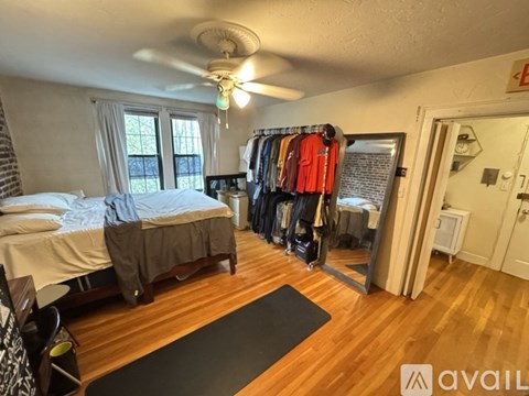 A bedroom with a bed, a closet, and a ceiling fan.