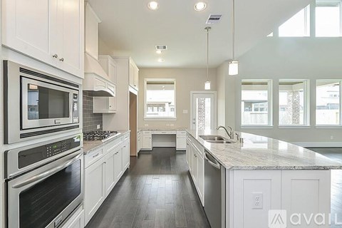 A modern kitchen with white cabinets and stainless steel appliances.