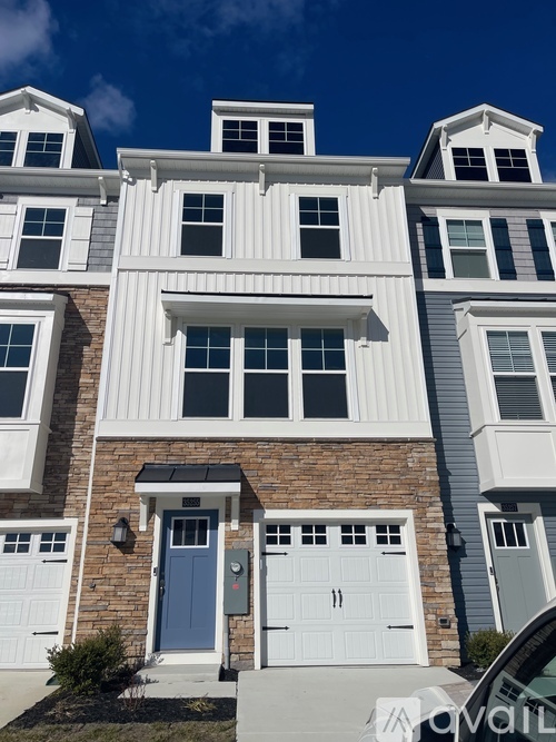 A row of houses with white and grey siding and blue doors.