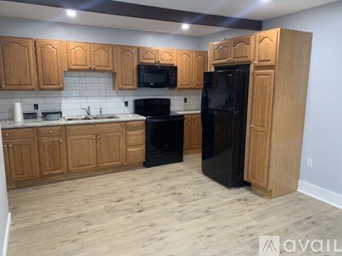 A kitchen with wooden cabinets and black appliances.