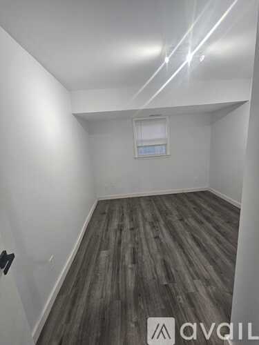 A room with wooden flooring and a window.