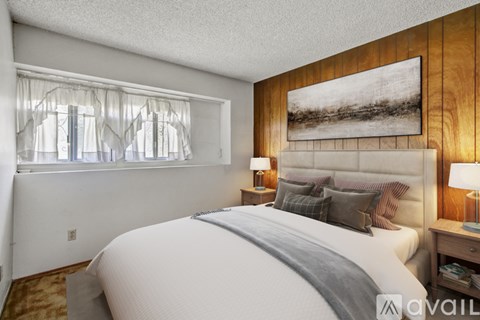 A bedroom with a large bed and a painting on the wall.