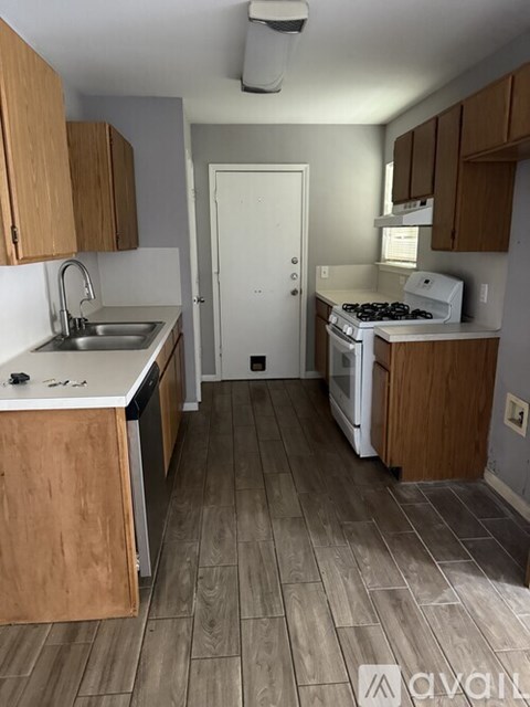 A kitchen with wooden cabinets and a white stove top oven.
