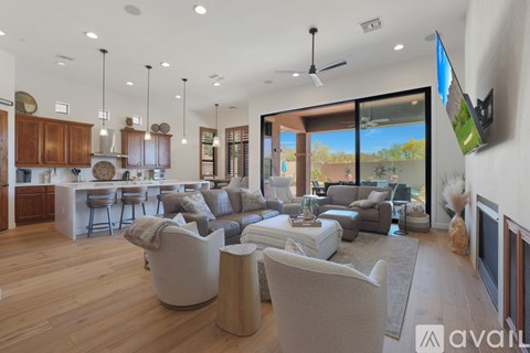 A living room with a television and a kitchen area in the background.