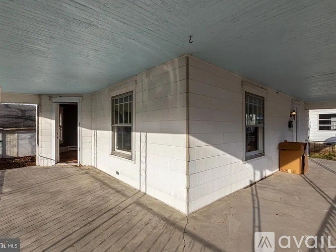 A wooden deck with a white building in the background.