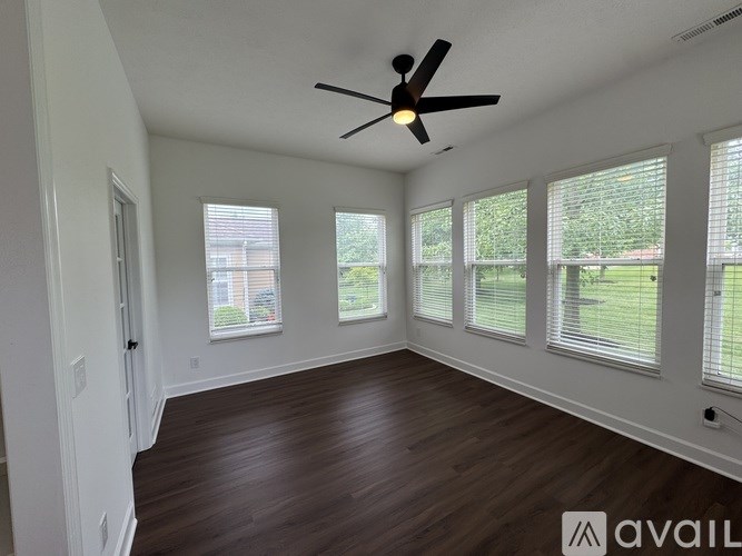 A room with a ceiling fan and wooden flooring.