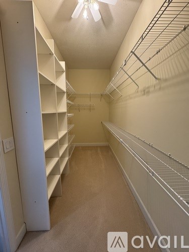 A long hallway with shelves on the side and a light on the ceiling.