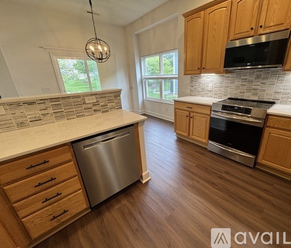 A kitchen with wooden cabinets and a stainless steel dishwasher.