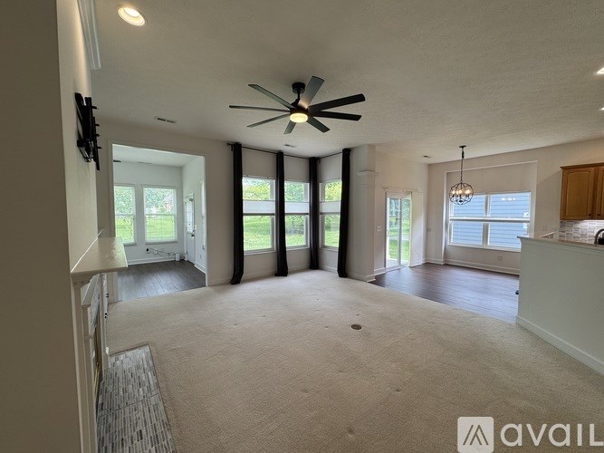 A spacious living room with a ceiling fan and sliding glass doors.