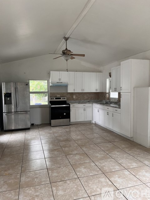 A kitchen with white cabinets and a tile floor.