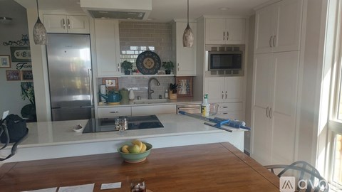 A kitchen with a wooden table and a bowl of fruit on it.
