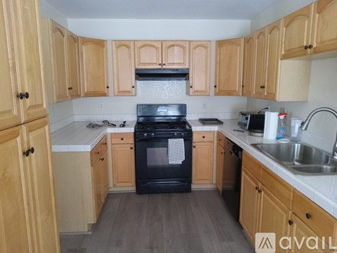 A kitchen with wooden cabinets and a black oven.