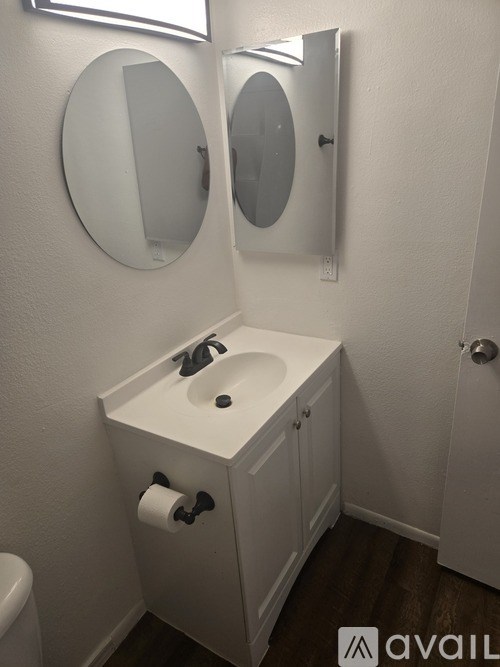 A small white bathroom with a sink and mirror.