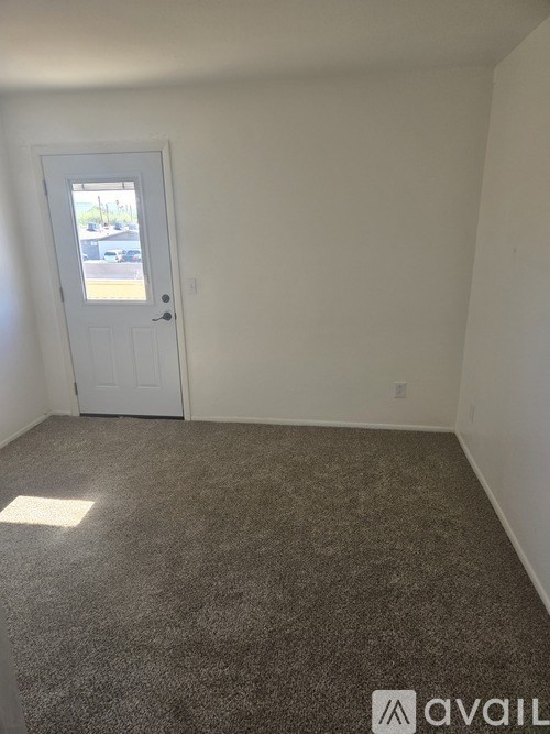 A room with a carpeted floor and a white door.