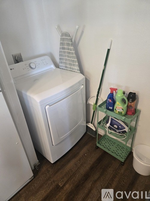 A white dryer is next to a white washing machine in a small laundry room.