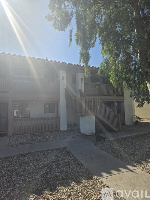 A building with a balcony and a tree in front of it.