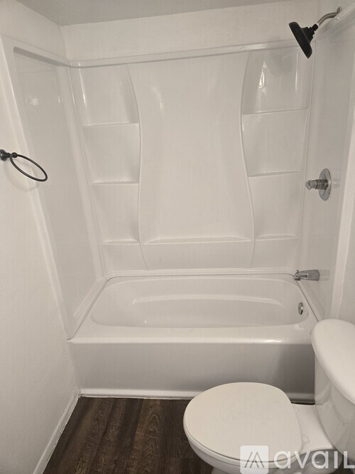 A white bathroom with a toilet and a bathtub.