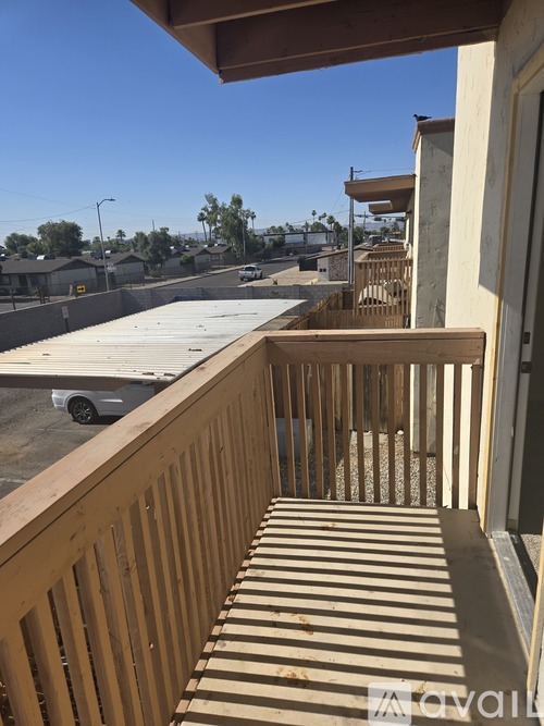 A balcony with a view of a parking lot and buildings.