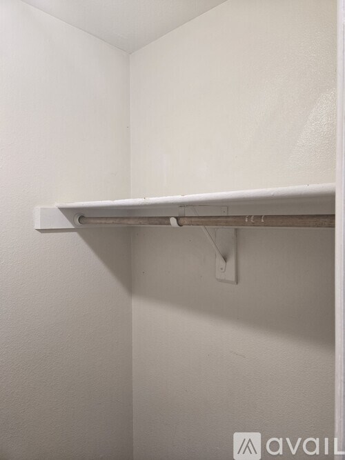 A white shelf is mounted on a white wall.