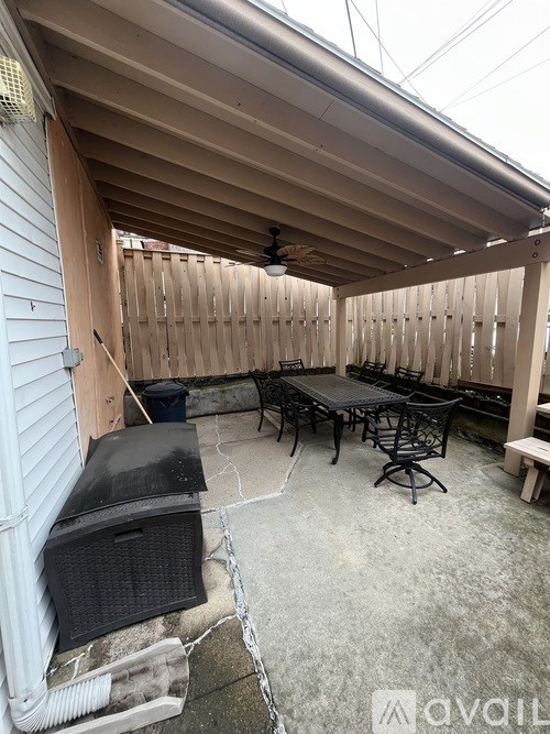 A patio with a table and chairs under a roof.