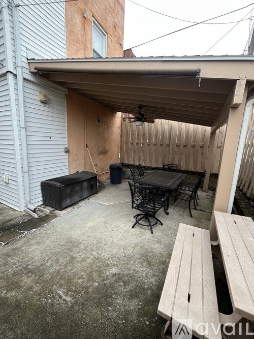 A patio with a table and chairs under a roof.