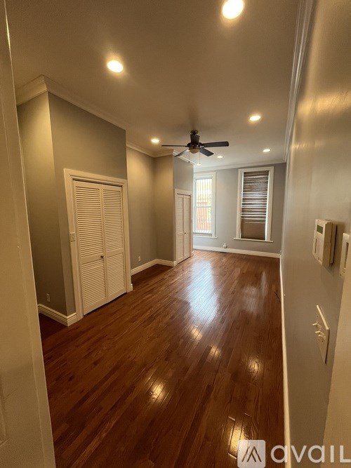 A room with wooden floors and a ceiling fan.