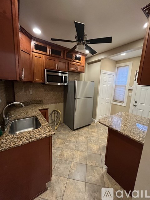 A kitchen with brown cabinets and a stainless steel refrigerator.