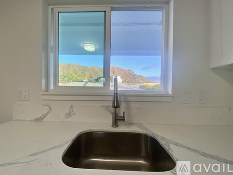 A kitchen sink with a window showing a view of the outdoors.