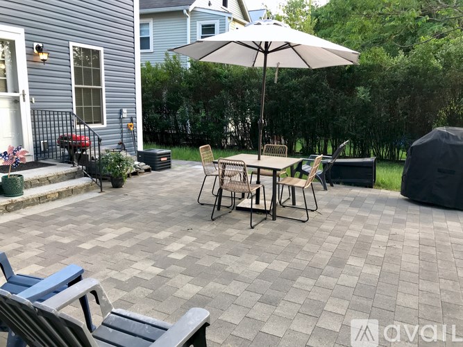 A patio with a table and chairs under an umbrella.