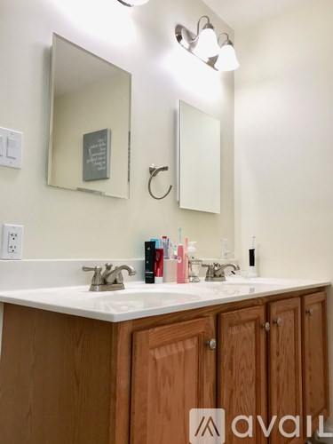 A bathroom with a sink, mirror, and cabinets.