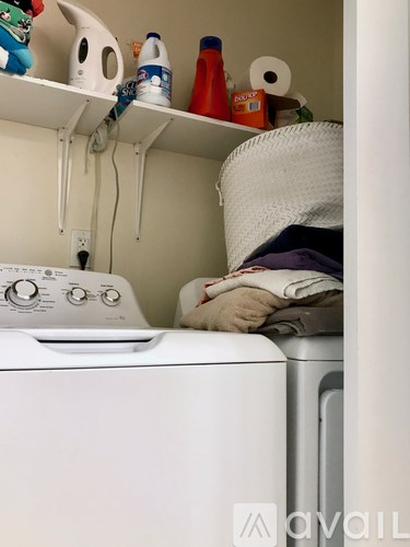 A white washing machine with a basket on top of it.