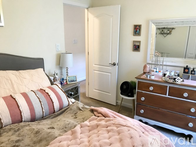 A bedroom with a bed, dresser, and mirror.