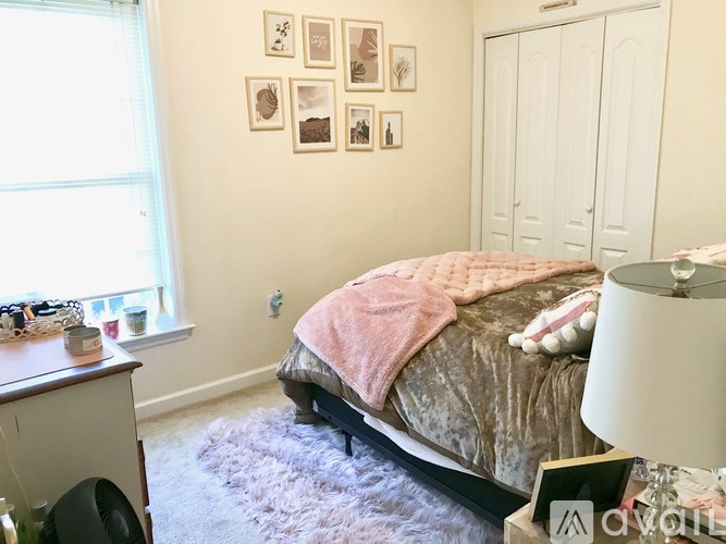 A bedroom with a bed, a nightstand, and pictures on the wall.
