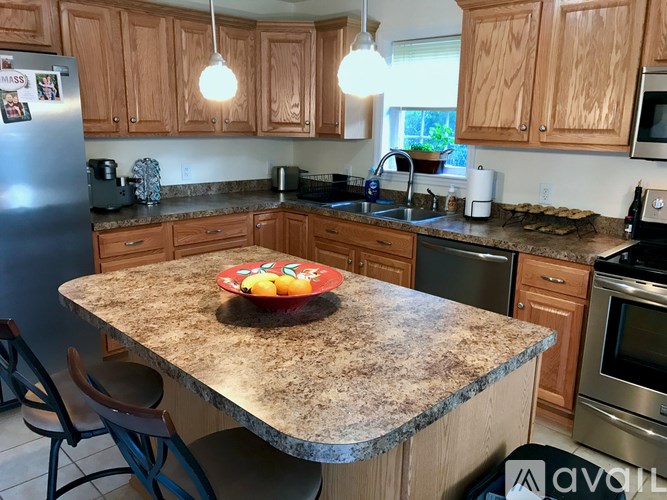 A kitchen with granite countertops and wooden cabinets.
