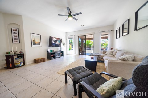 A living room with a black couch and a television.