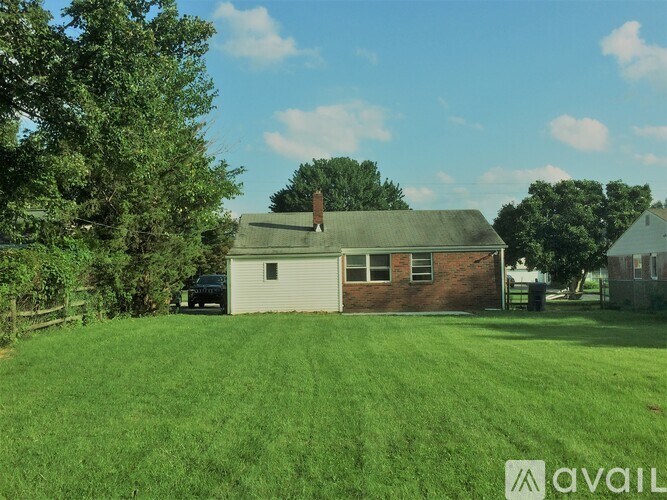 A house with a green lawn in front of it.