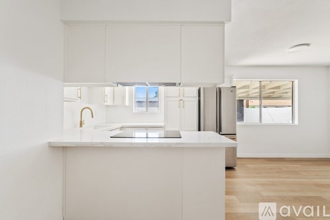 A modern kitchen with white cabinets and a central island.