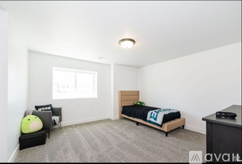 A bedroom with a bed, a desk, and a window.