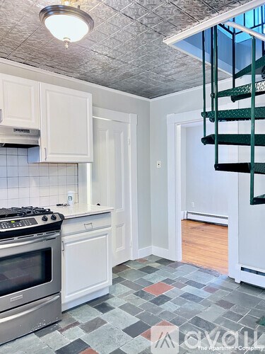 A kitchen with a stove top oven and a checkered floor.