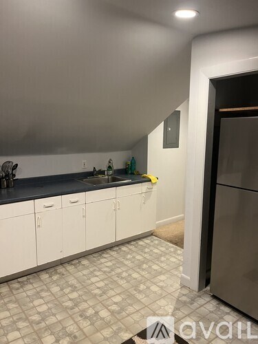 A kitchen with white cabinets and a black countertop.