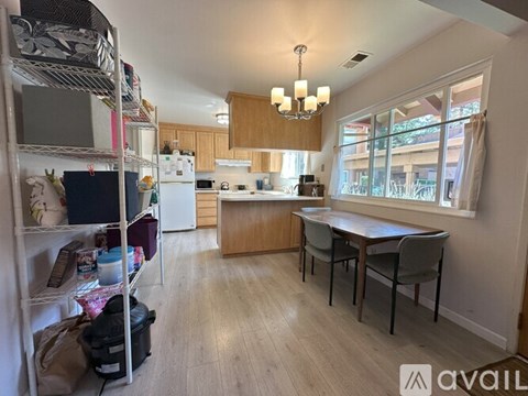 A kitchen with a table and chairs in front of a window.